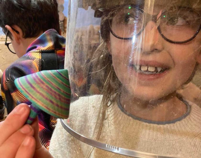 A smiling girl holding a spinning top