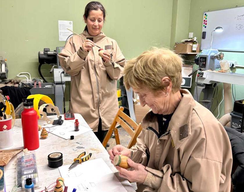 2 ladies decorating their own Christmas decorations.