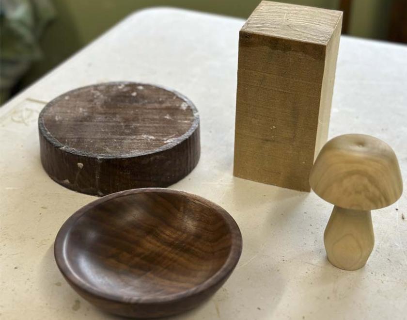 Blocks of wood next to finished pieces of woodturning.