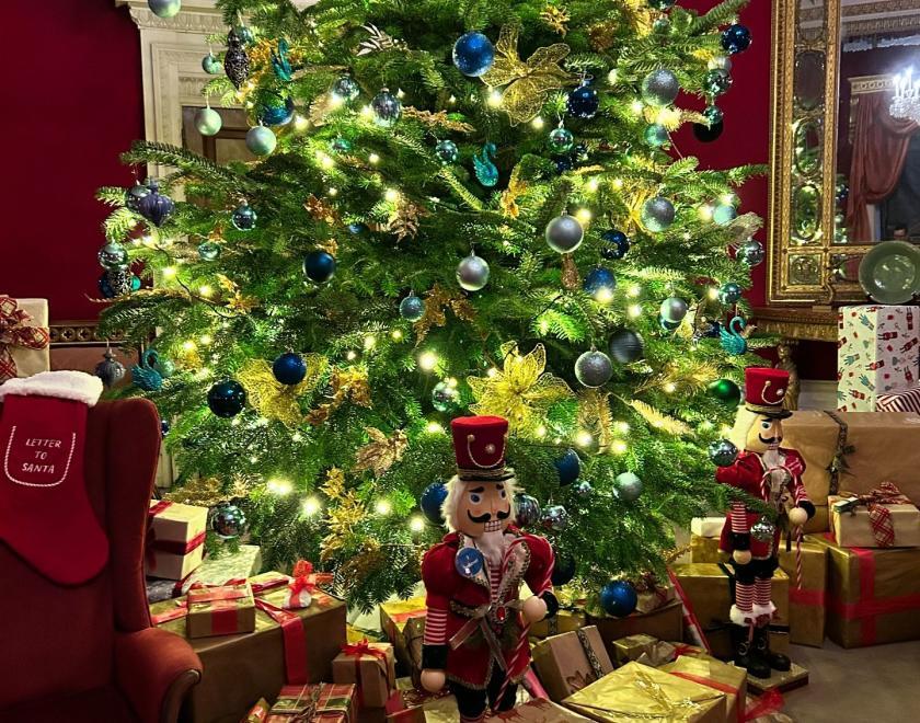 room in Basildon Park decorated with a Christmas tree and gifts under the tree