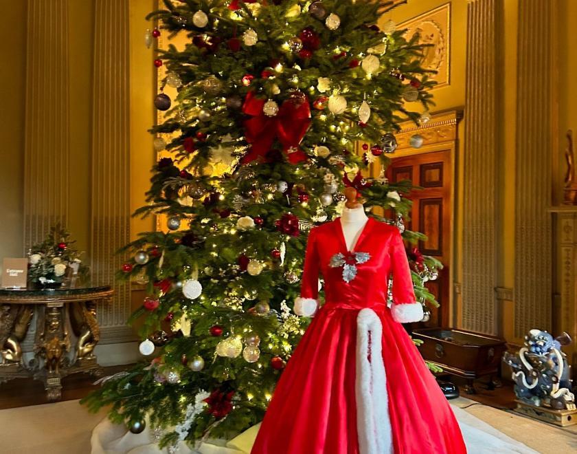 room in Basildon Park decorated with a Christmas tree and a red dress that represents the film White Christmas