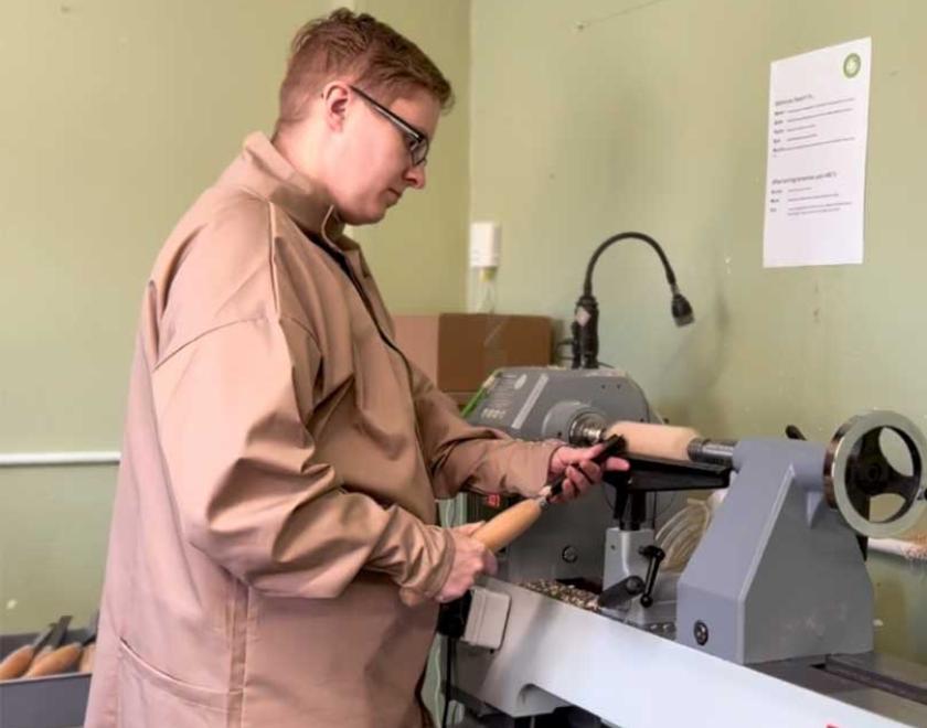 A woman woodturning at the lathe.