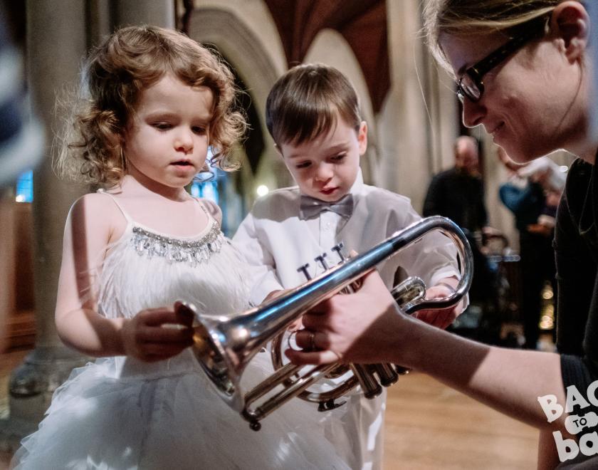 two children inspect a trumpet at a bach to baby concert