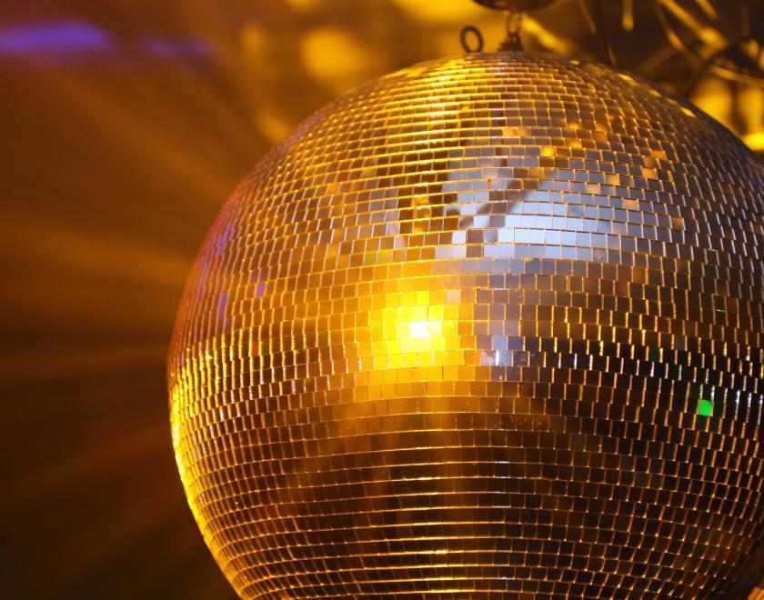 Glitter ball hanging, with gold light flashing lights onto surroundings
