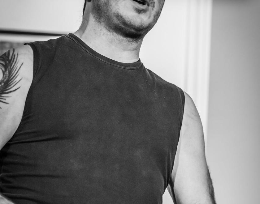 Black and white image of Damien Barber singing and playing concertina