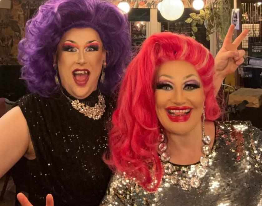 Drag queens Miss Charley O'llocks & Grace Anatomy in sparkly dresses, big wigs and big make up