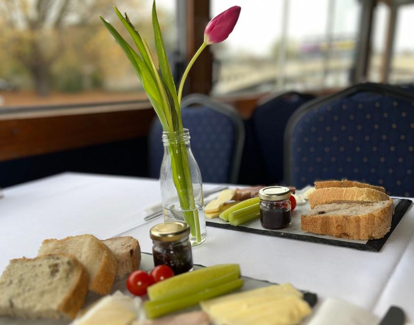 table for 2 set with tulips in vase, each with own ploughmans type lunch