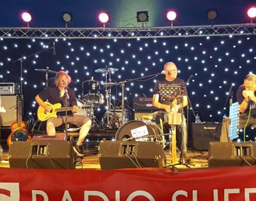 four men on stools on stage