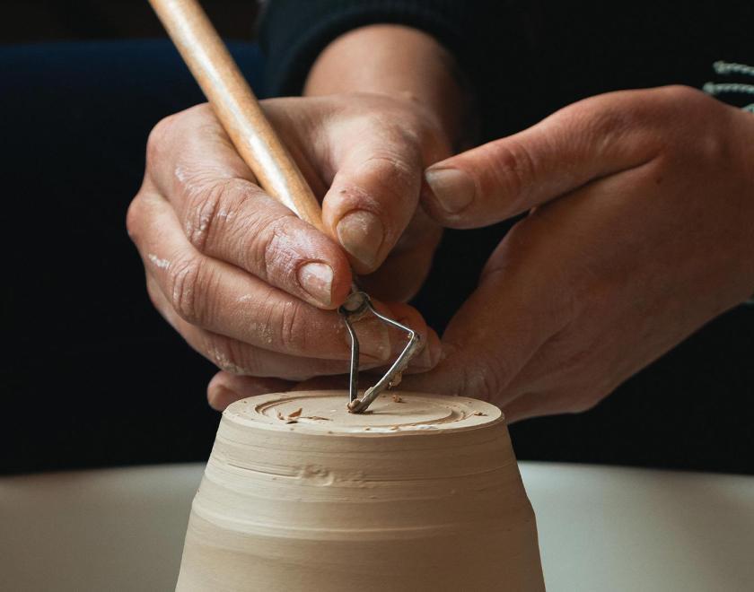 Hand sculpting a clay pot