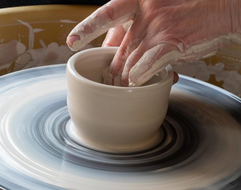 Hand throwing a ceramic pot using a wheel