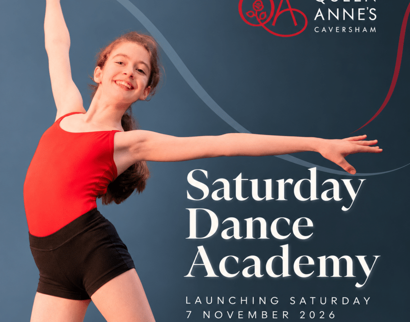 Girls in red leotard and black shorts performing a dance move with arms outstretched