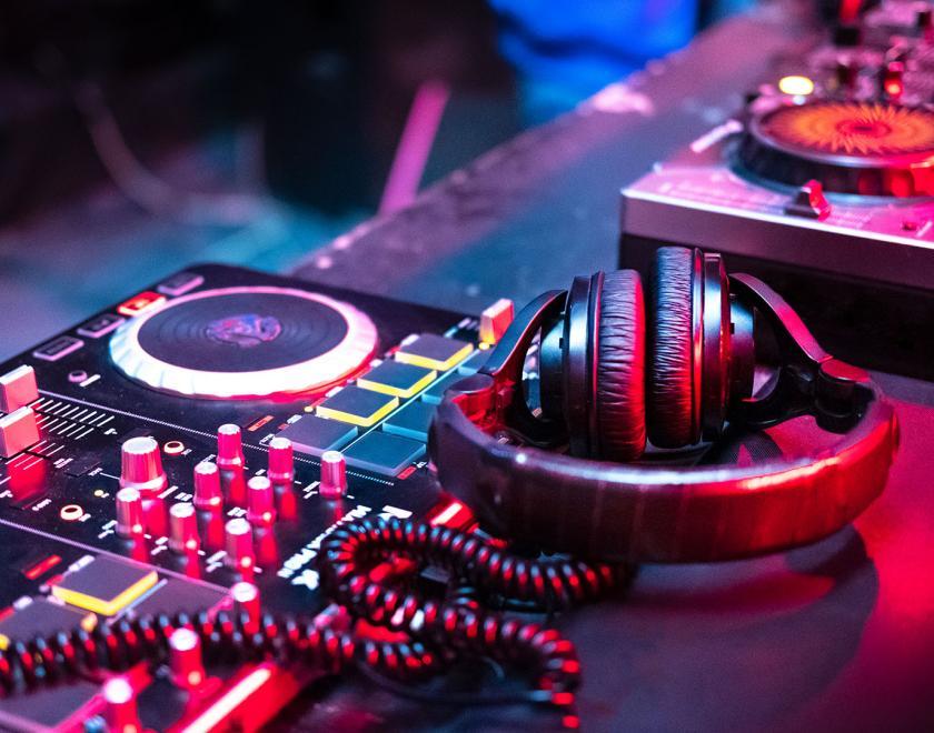 Stock image of DJ decks and headset bathed in pink and blue light