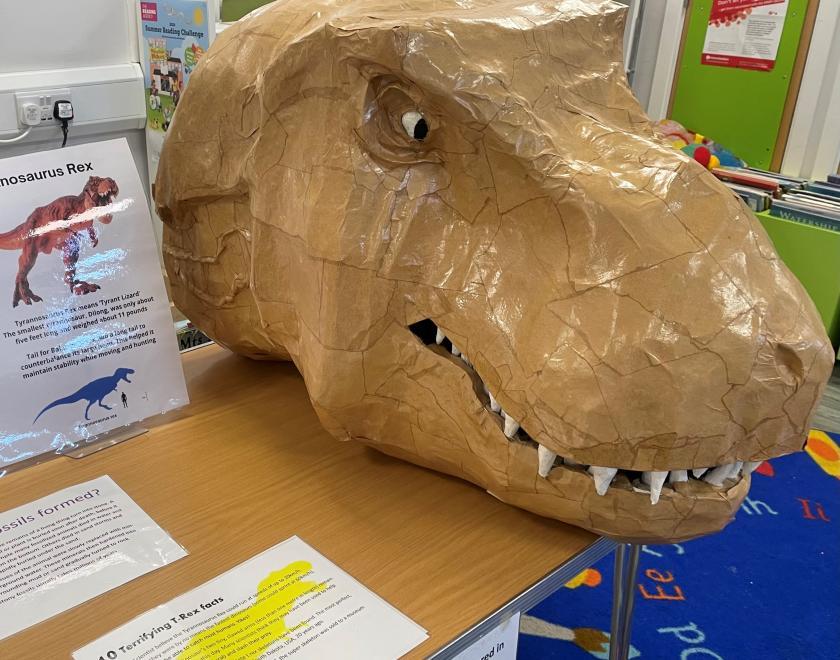 Photograph of a large craft made TREX cardboard head on a desk