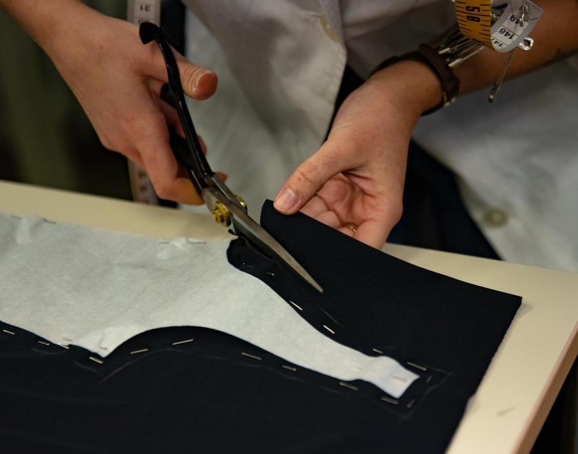 Hands cutting a cloth with scissors