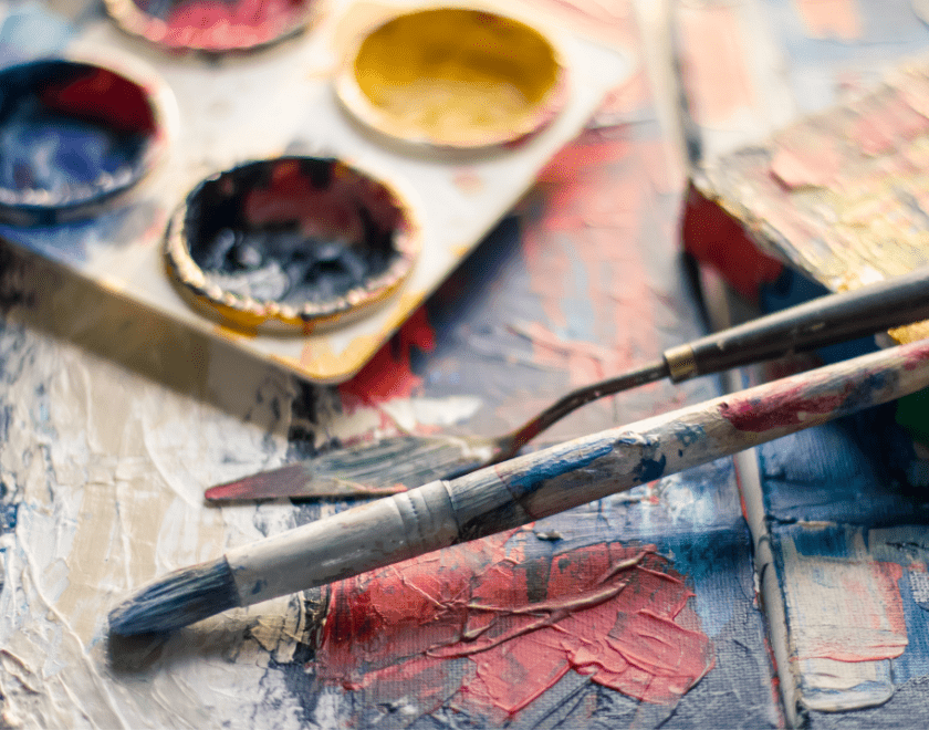 Watercolours and a paintbrush on a table
