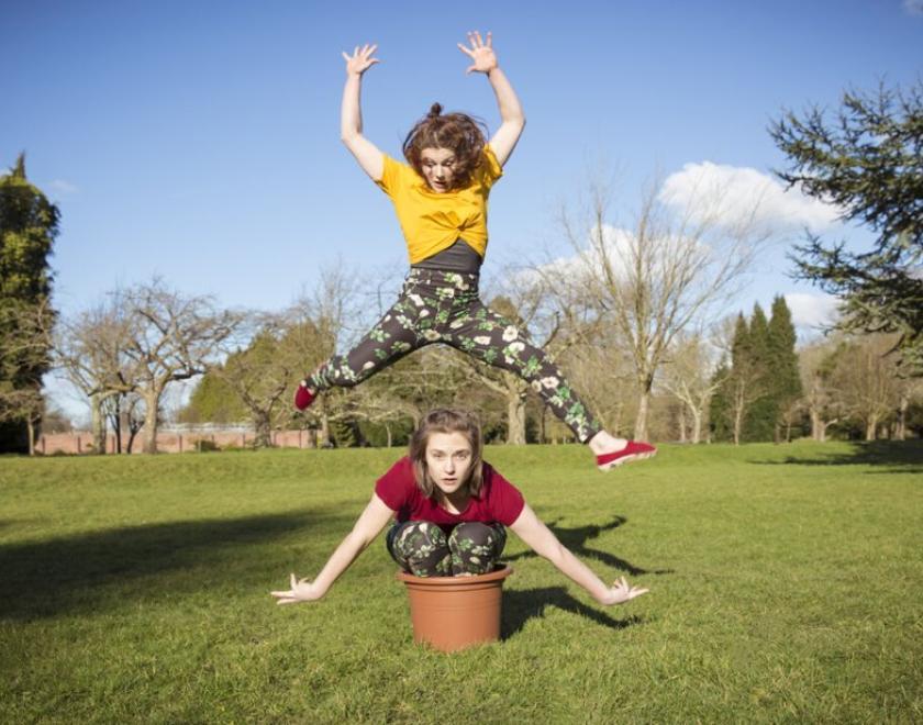 Dancer in a plant pot, with another dancer jumping above them