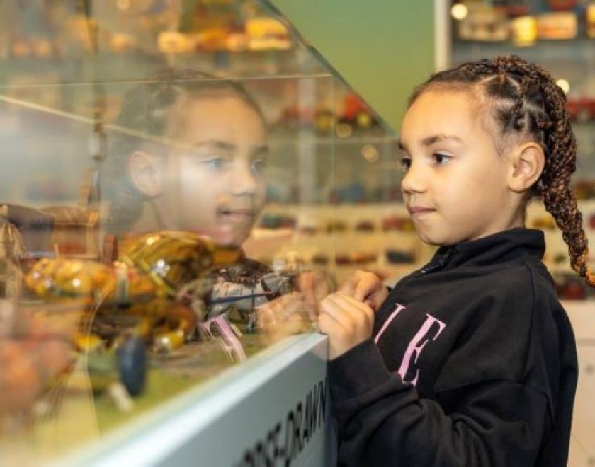 Girl in the MERL galleries looking into the toy case