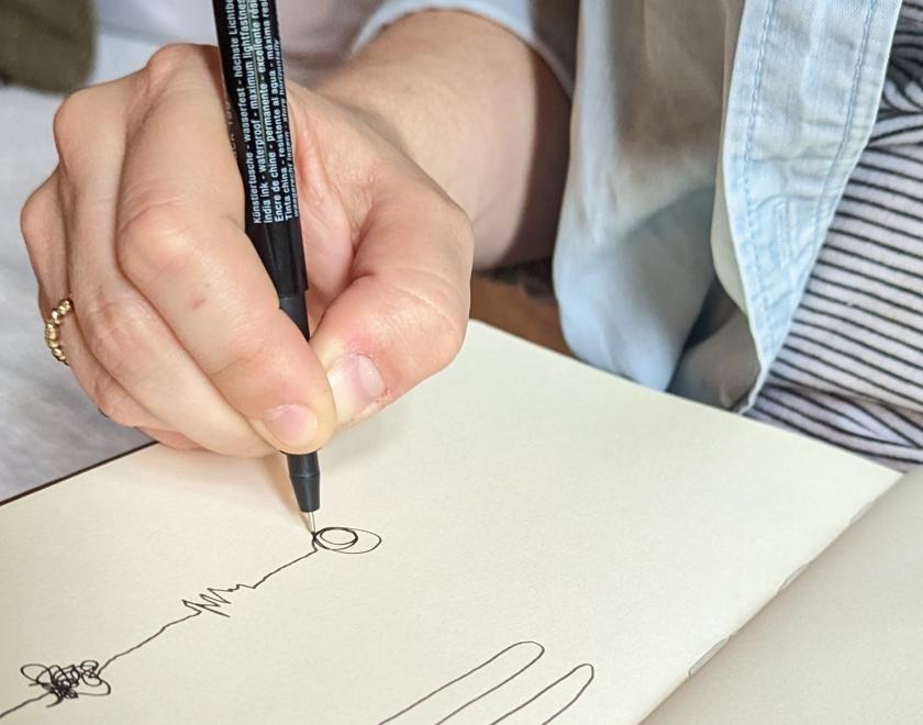 Image of a hand drawing lines on a page