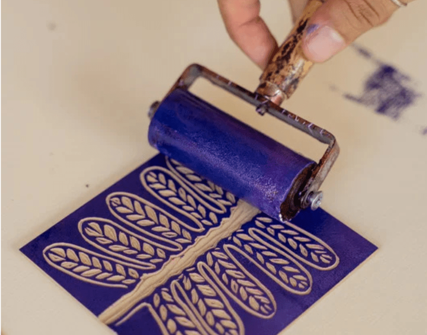 Hand using a linocut printing roll