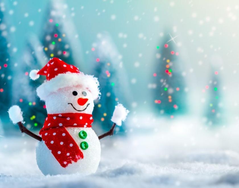 A happy snowman stands in a snowy scene wearing a bright red hat and scarf