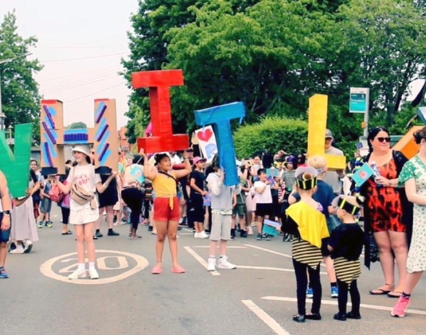 People at Whitley Carnival holding up giant letters spelling W H I T L E Y