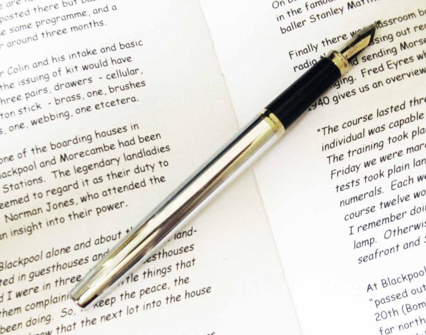 fountain pen lying on top of a biography