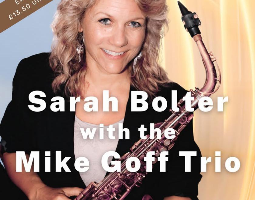 Female saxophonist with blonde hair and a black jacket