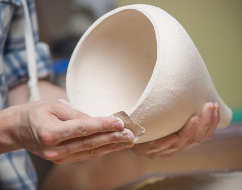 Hands shaping a pot