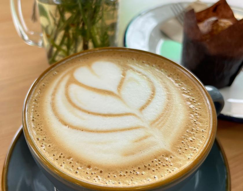Latte art, muffin and plant