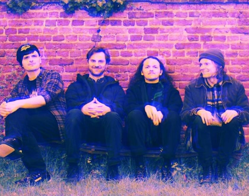 doops band sitting in front of a wall