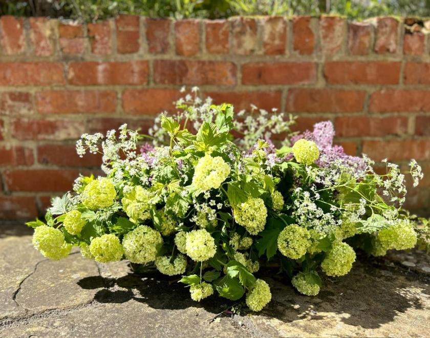 Wild vase arrangement of Spring flowers in green, lilac and white