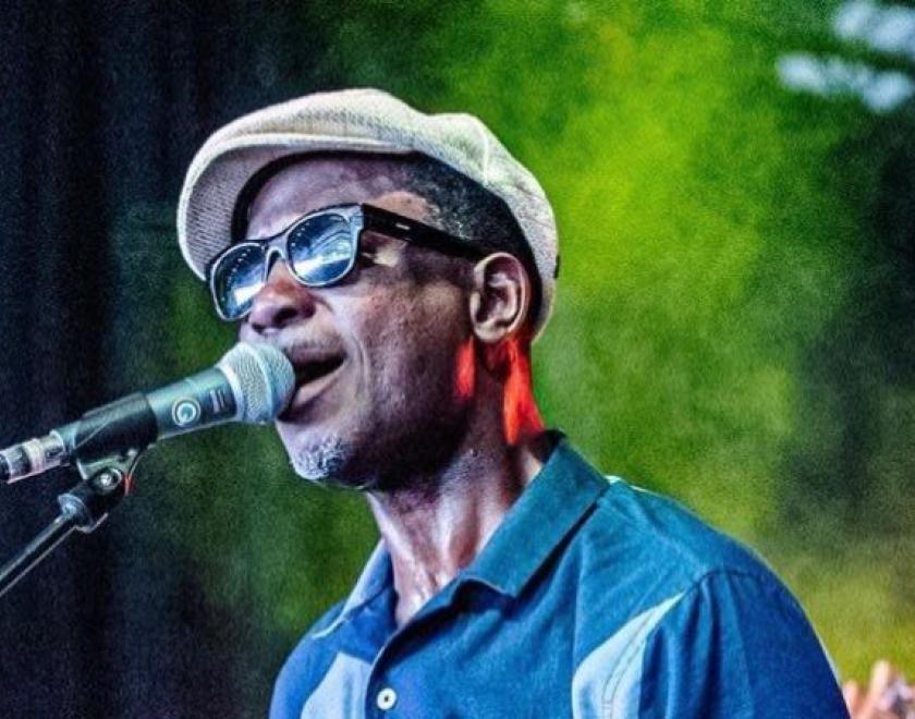 bluesman Errol Linton singing into a microphone
