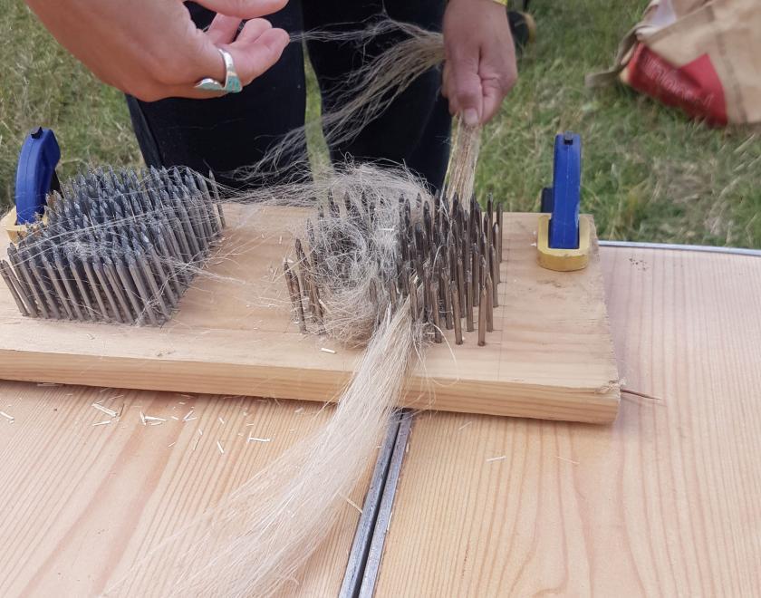 A person using a hackle with flax