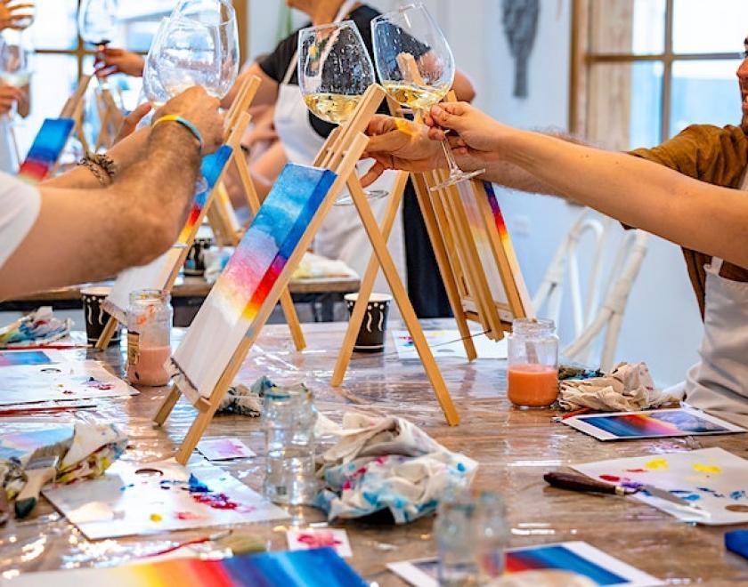 An art class cheers-ing glasses of prosecco