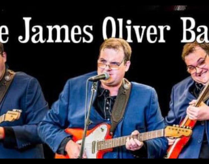 three James Oliver's - a bespectabled man playing guitar in a blue suit