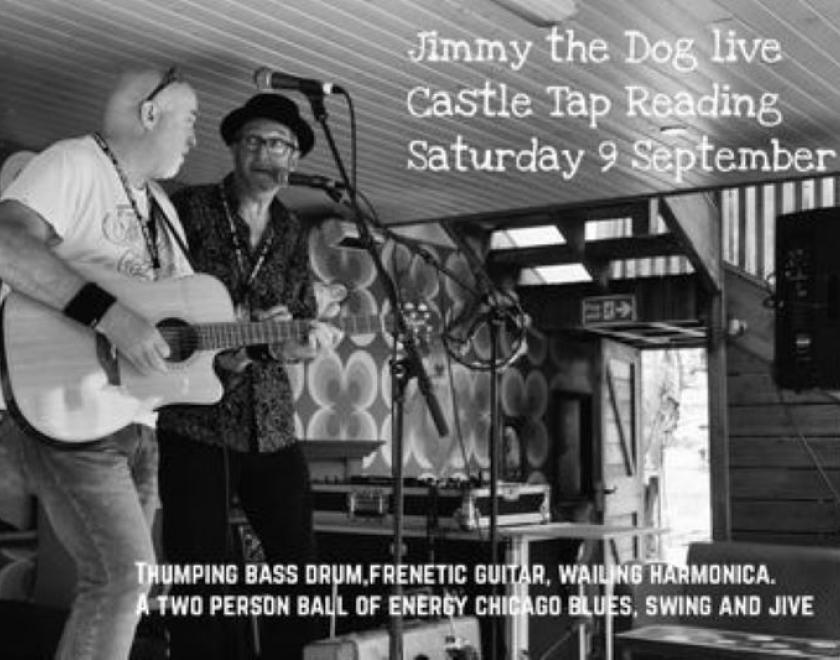 Black and white image of two white-skinned older male musicians standing behind mics on the left of the picture. The slightly nearer person is holding a guitar. The ceiling is low and the wallpaper behind them looks like 70s kitsch.
