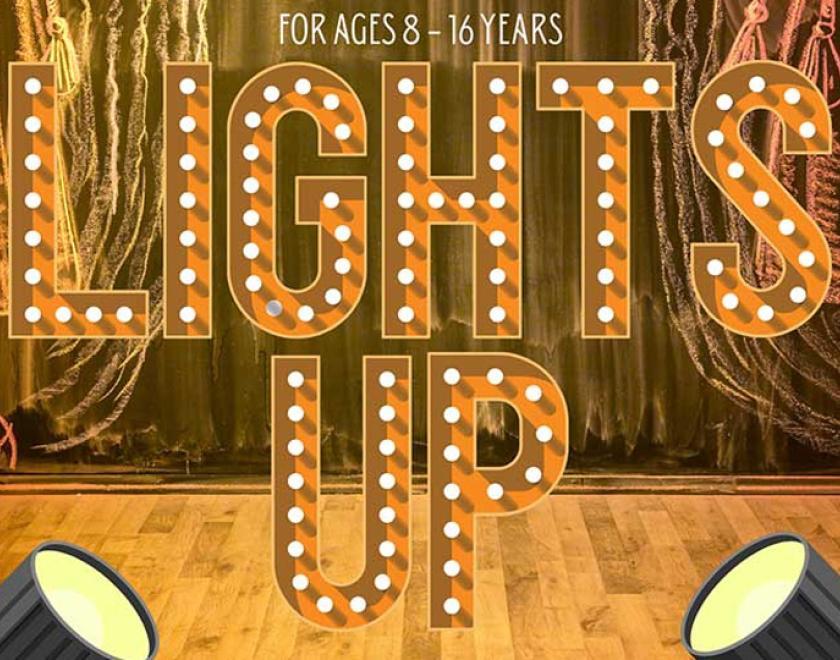 The word "lights up" spelt out in theatrical lettering with lightbulbs