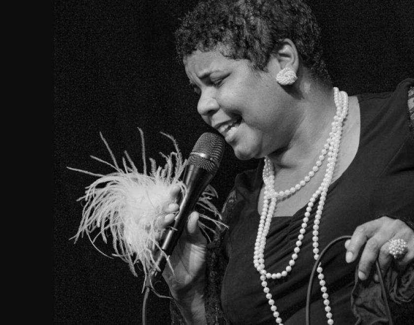 Singer Ma Bessie in vintage 1920s outfit singing into a microphone