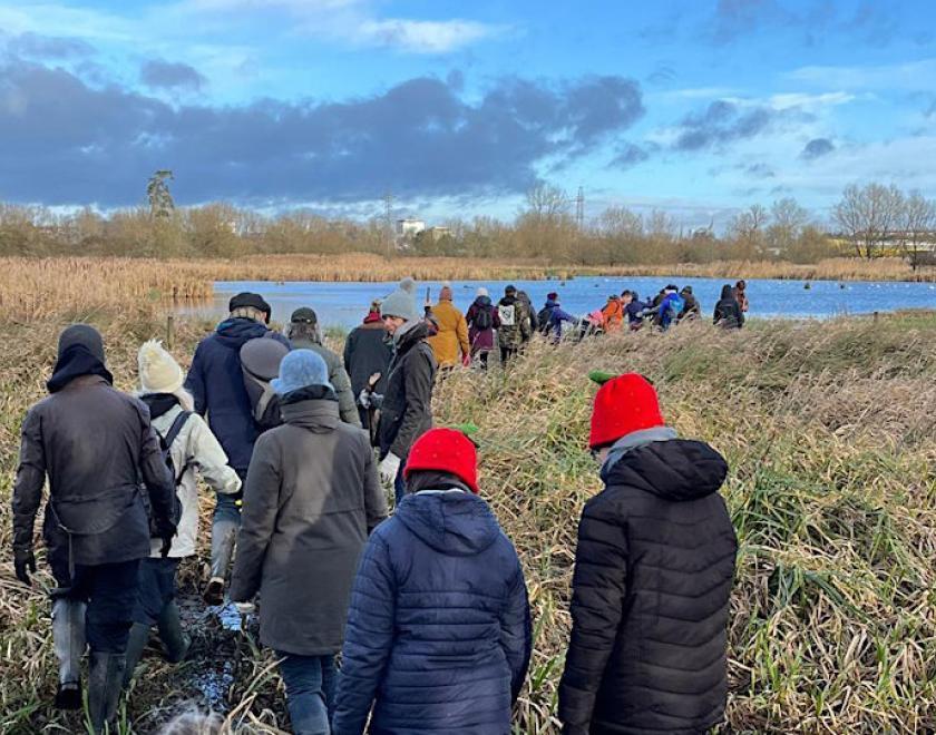 Group of people marching through marshland
