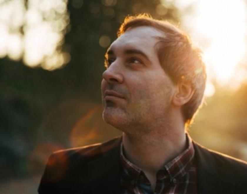 Ben Marwood stood in a wood. He has short dark hair and a checked shirt