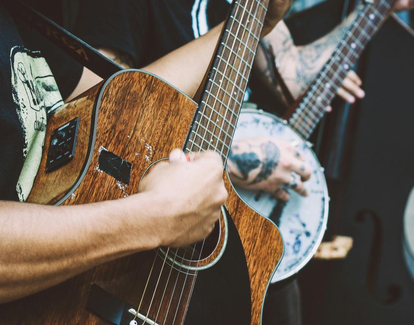 Stock image of people playing instruments; an acoustic guitar, banjo & double bass