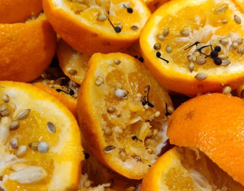A pile of slices of oranges covered in a smattering of spices and sugar