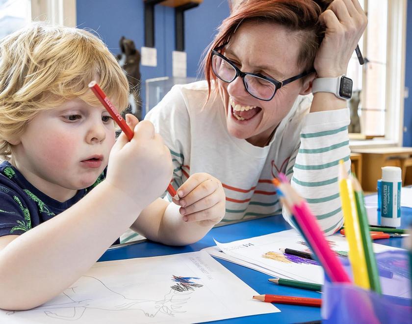 child and museum worker doing crafts