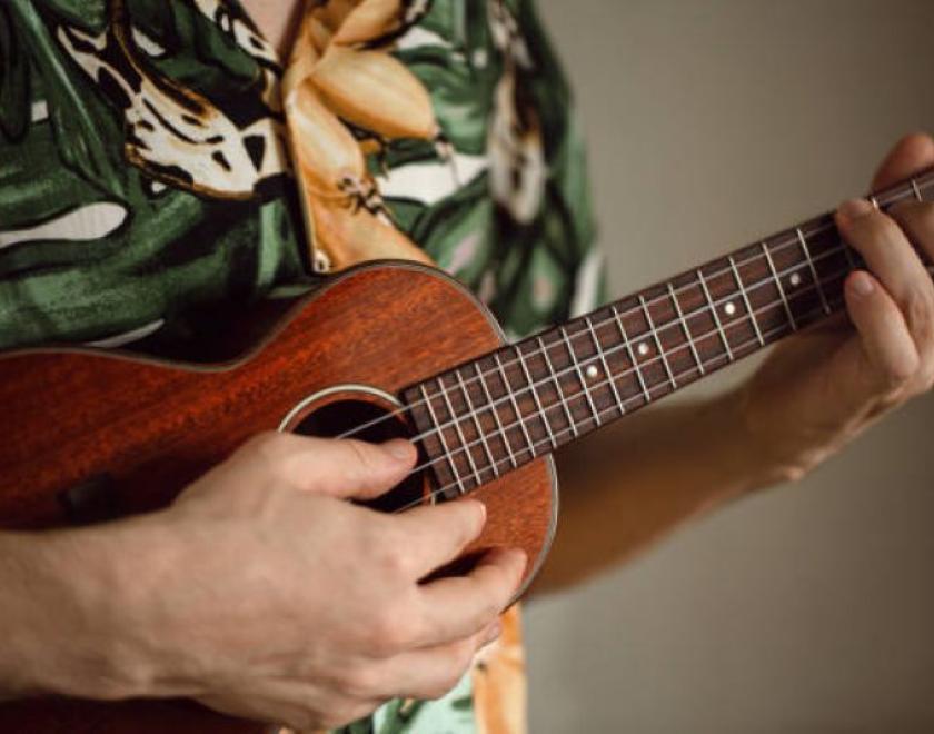 student holding ukulele