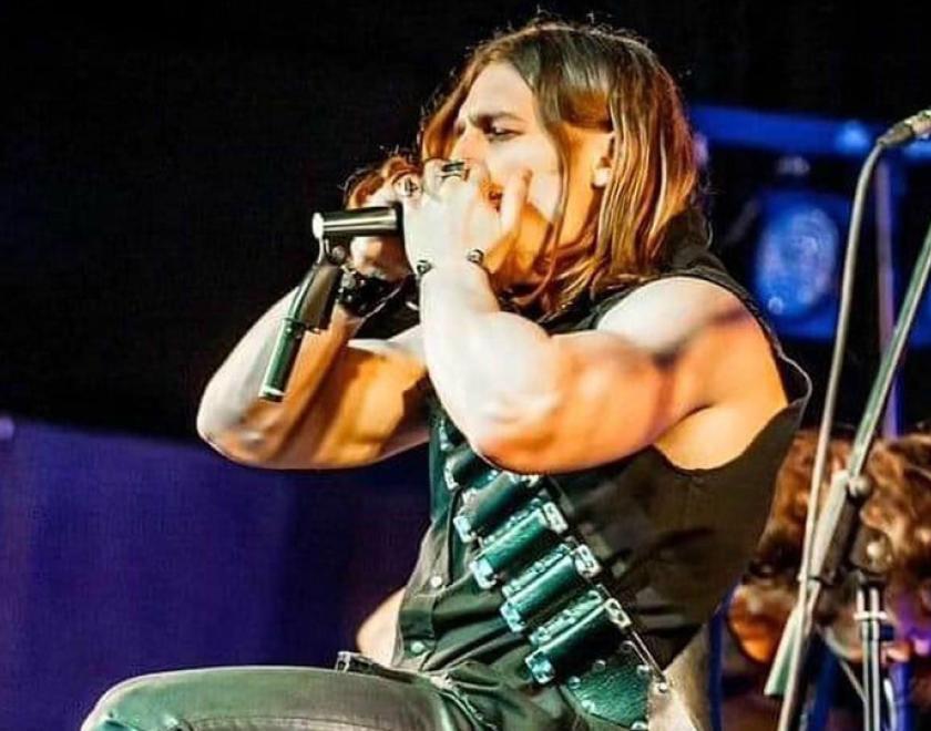 long-haird man playing the harmonica on stage