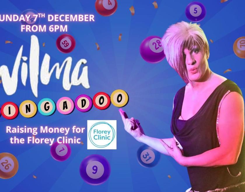 A drag queen and various bingo balls in the background