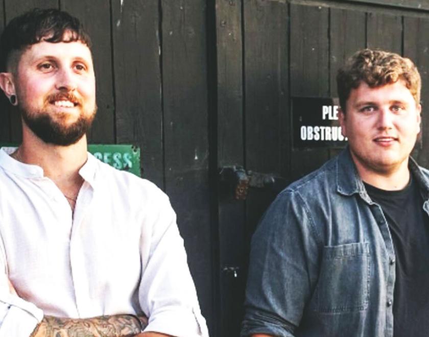 Musicians Wilswood Buoys, two white men standing against a wooden door