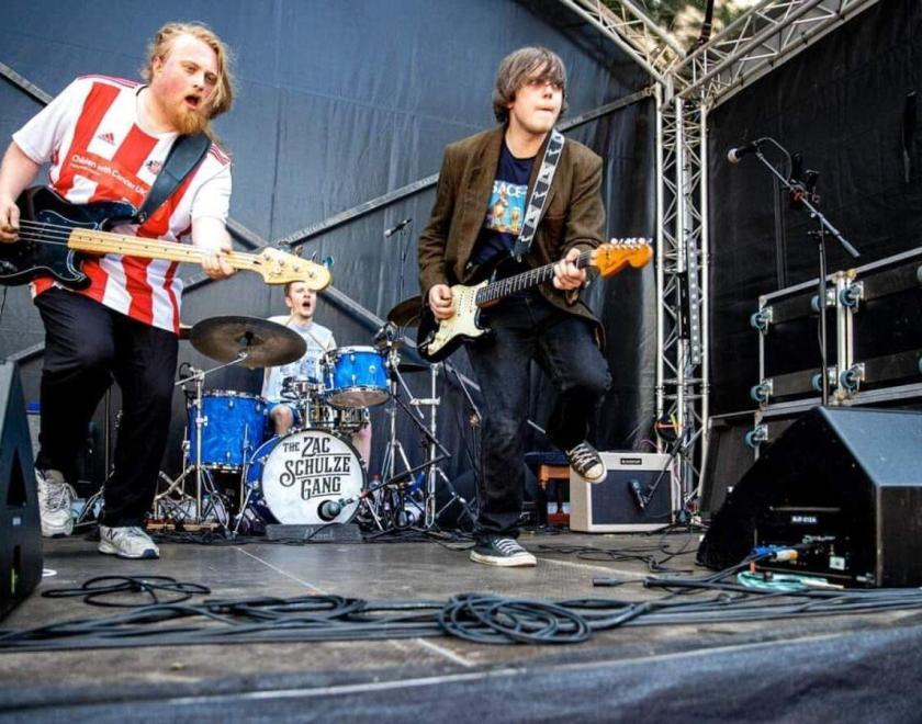 three man blues band The Zac Schulze Gang performing on stage. Bass, guitar and drums.